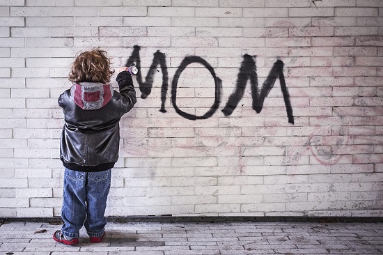 Child spray painting 'mom' on the wall, representing your mom comebacks